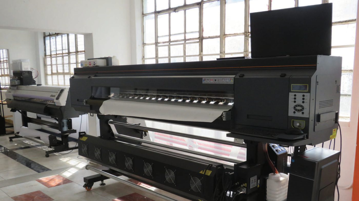 Large-format digital printer producing signage at the Artrivers Warehouse workshop